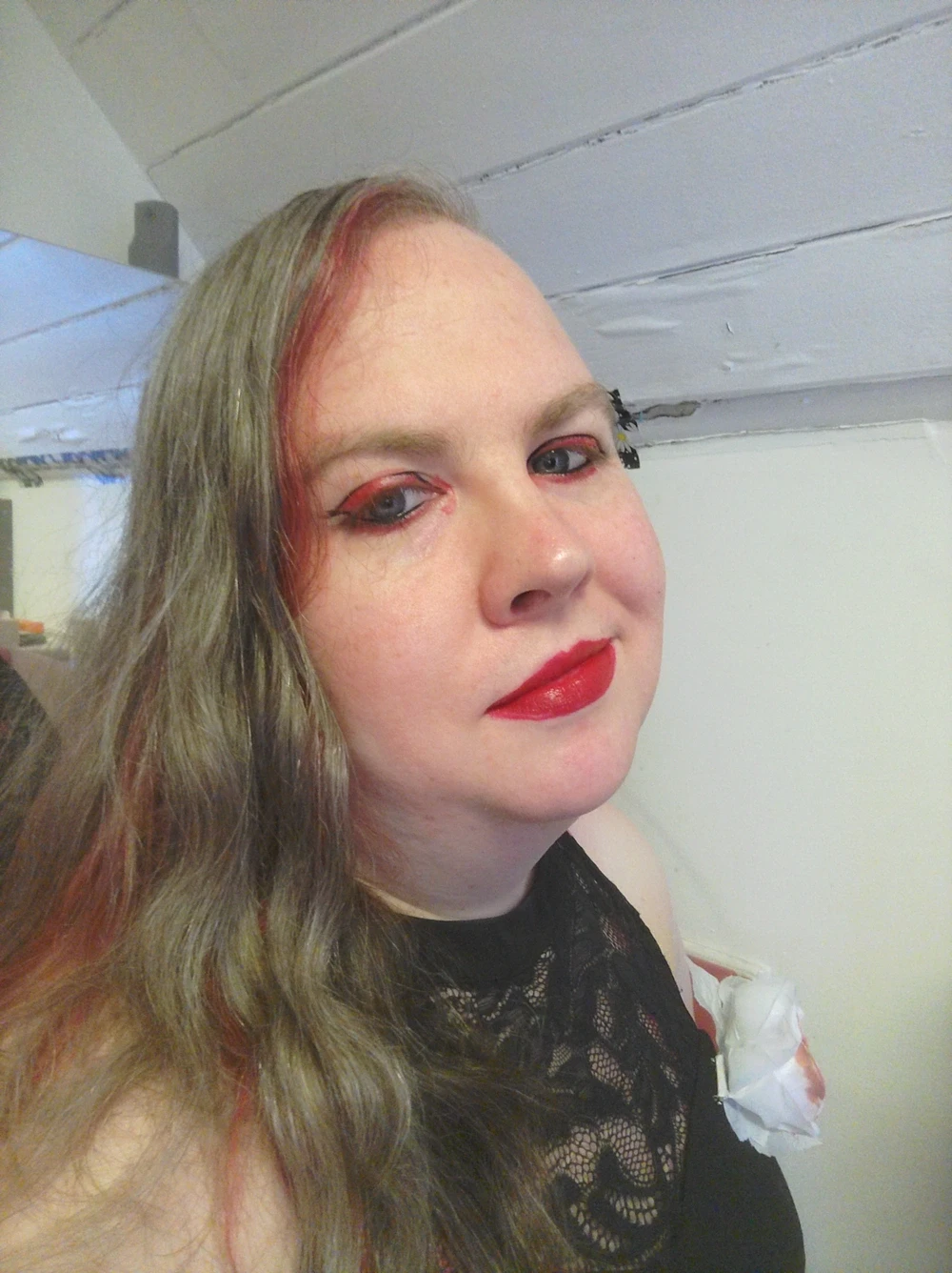 Me with dyed red streaks in my hair, red lipstick, a black dress and black and red eyeliner in imitation of the marks around Shadow the Hedgehog’s eyes.