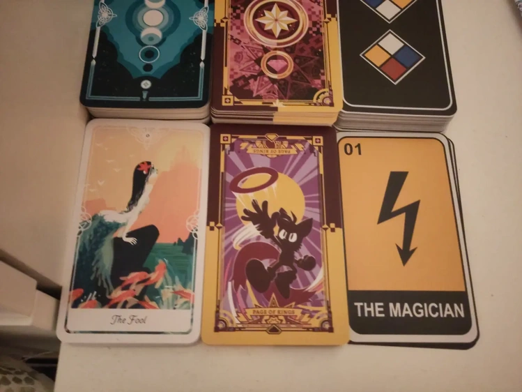Three tarot from three different decks. The fool (the little mermaid) from Yoshi Yoshitani’s Tarot of the Divine, the page of rings (Tails) from an official Sonic the Hedgehog tarot deck, and the magician (electricity warning sign) from Organical Mechanical’s hazard tarot deck.