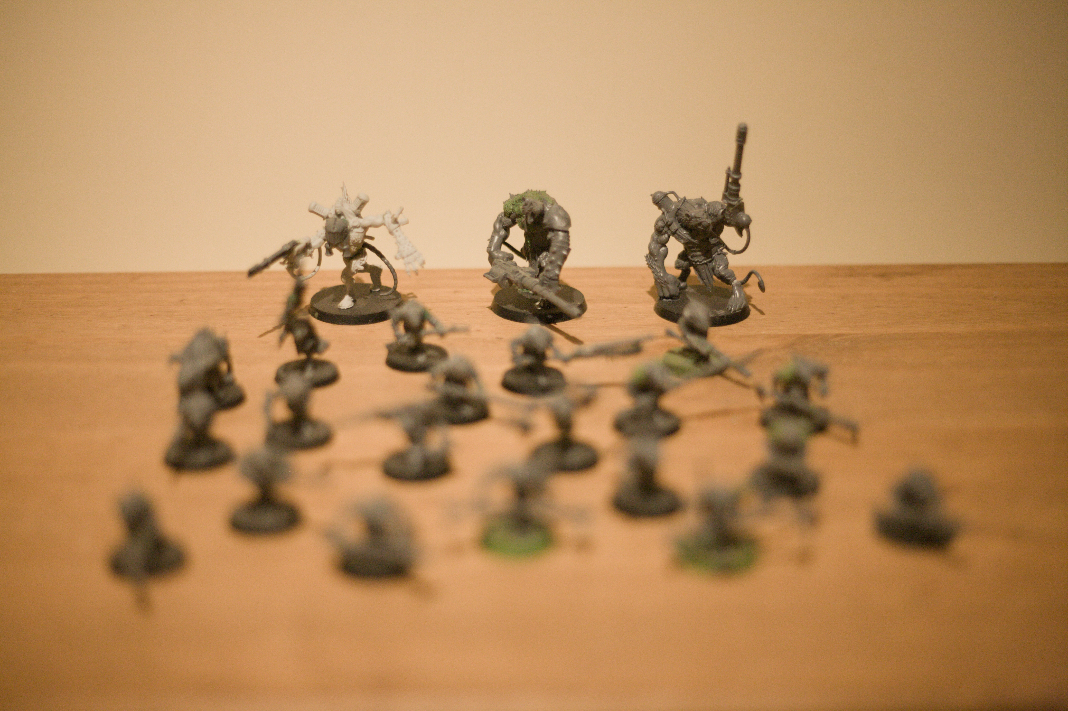 The giant rat men in the back are now in focus. One of them is carrying a large machine gun and the other two have similarly large gun barrels attached directly to their hands.